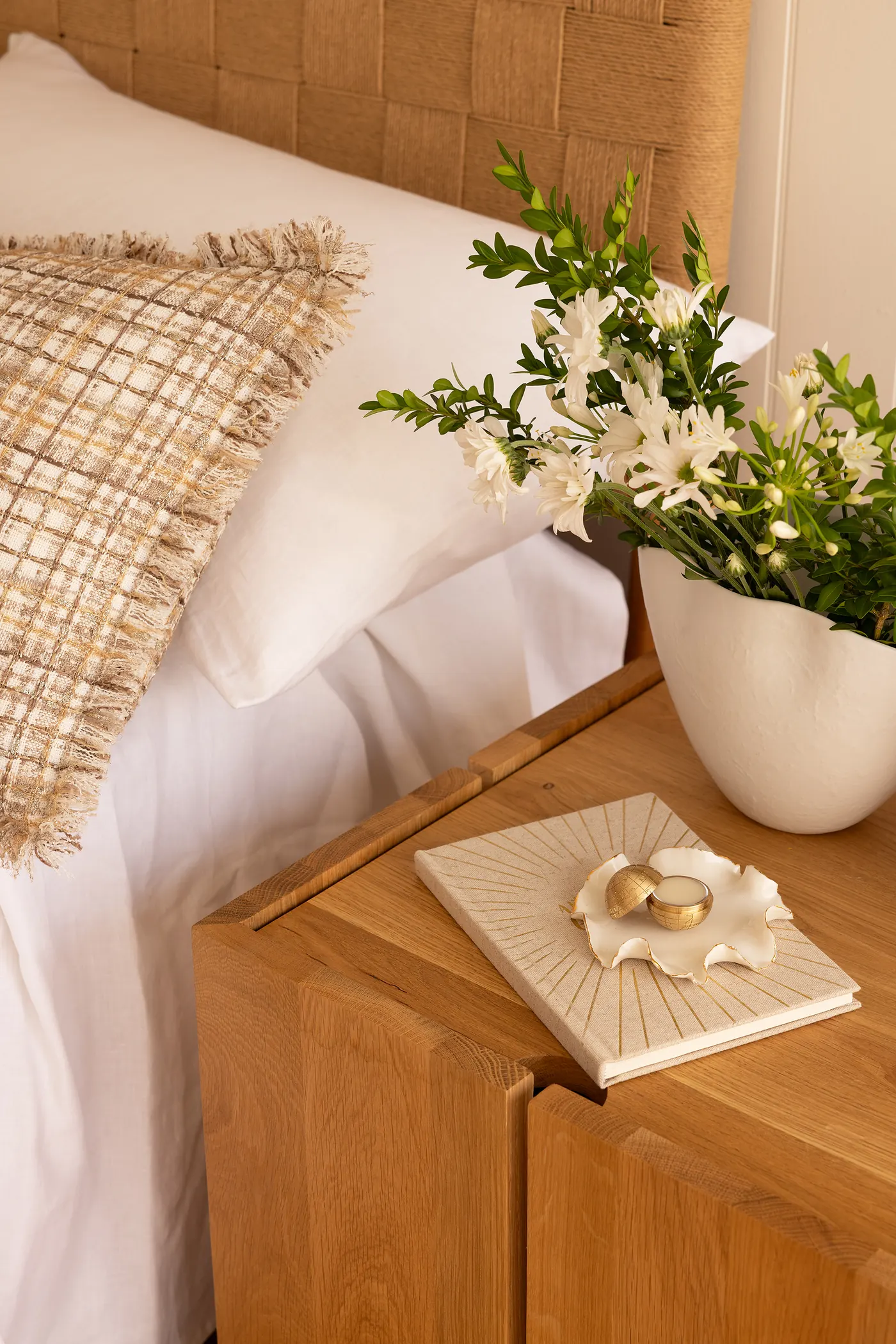 A brass globe on a ceramic dish on a bedside table