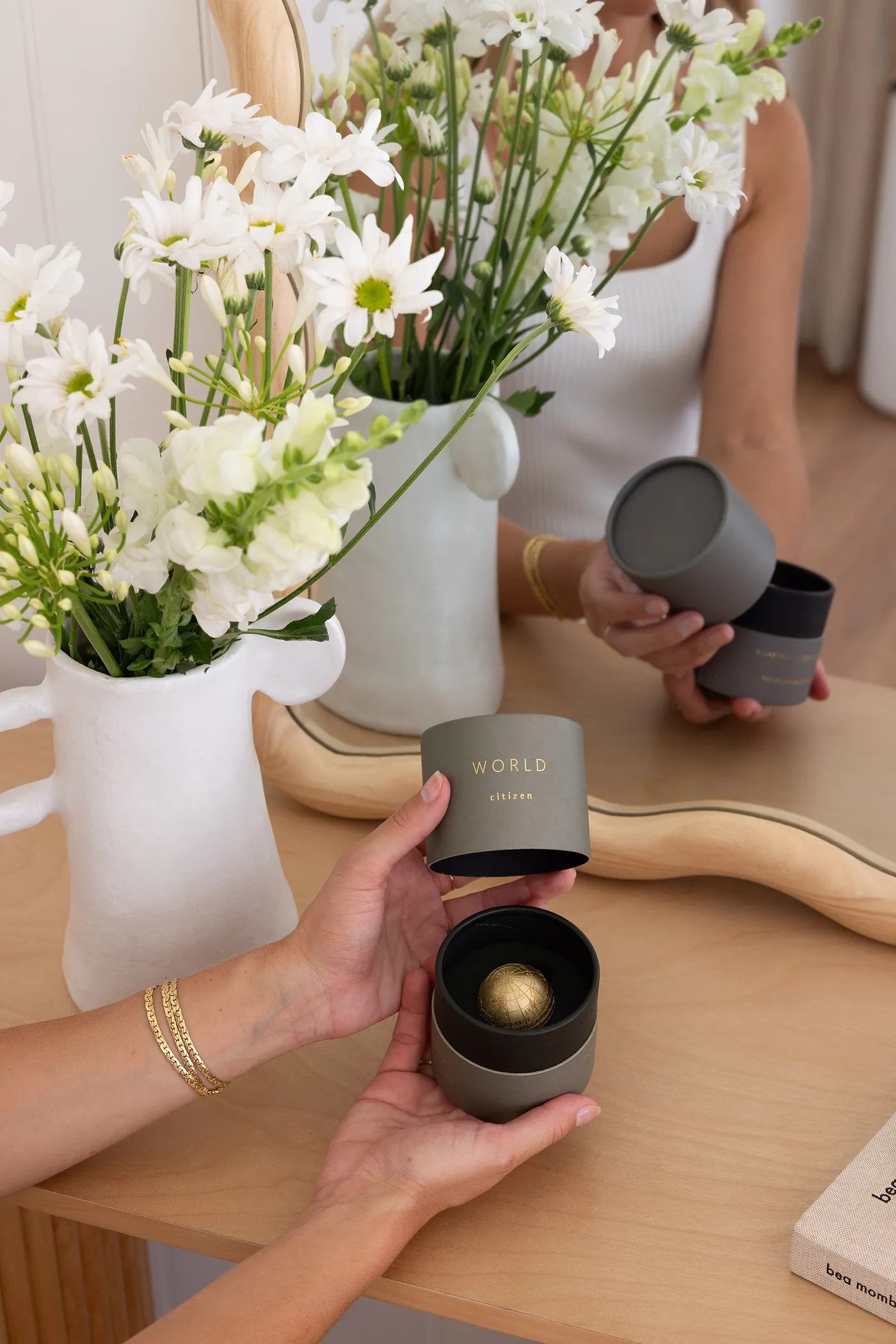 Handing over an open WORLD signature canister with the brass globe inside